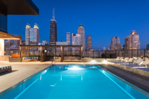 Outdoor swimming pool and lounge chairs at night